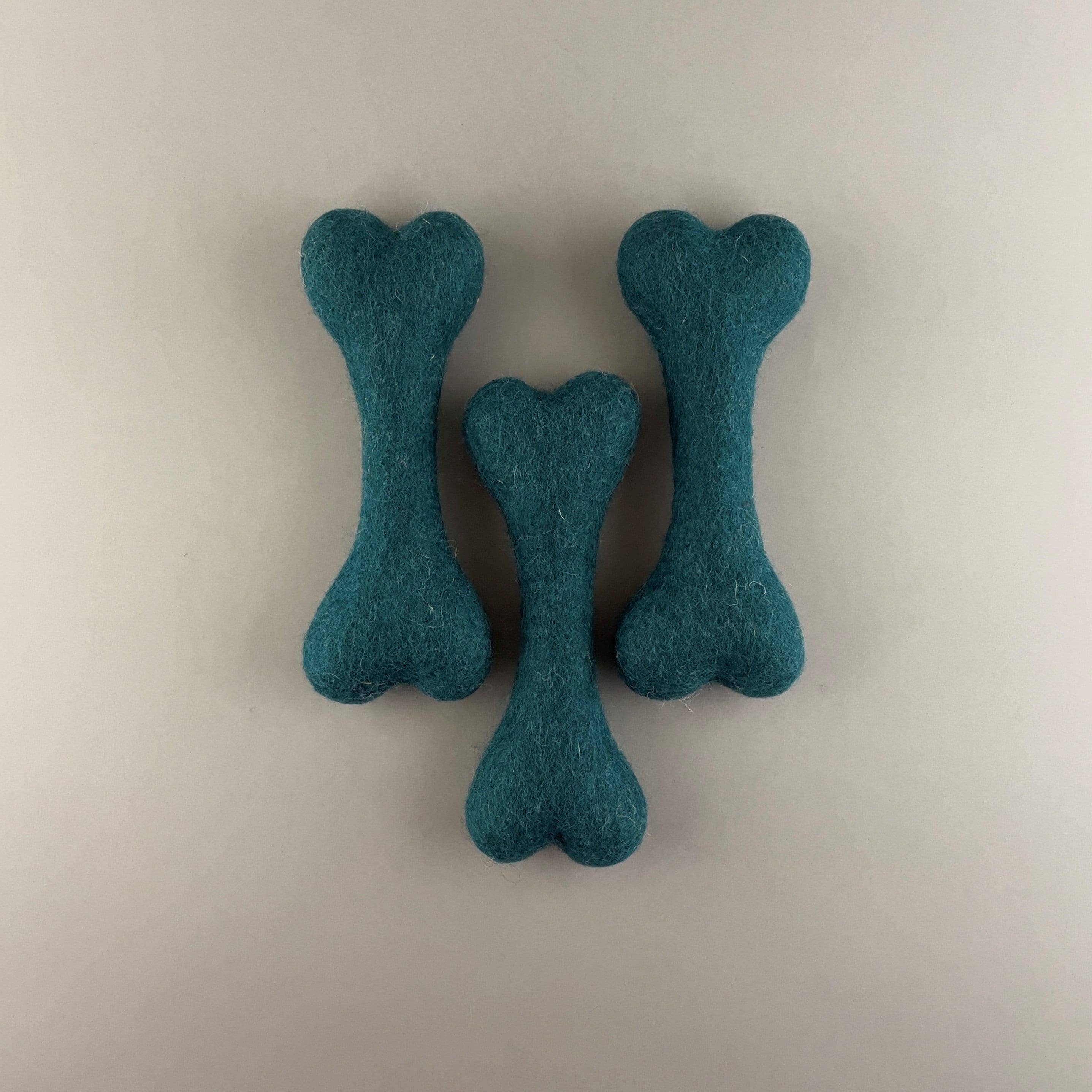 The Felted Wool Bone in vibrant Emerald Green and Pink, a 100% natural and plastic-free dog toy.