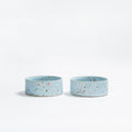 "A pair of Soft Blue New Party pet bowls in speckled stoneware with multi-colored glaze.