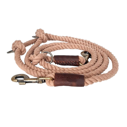 Beige rope dog leash with leather patches and brass hardware on a white background