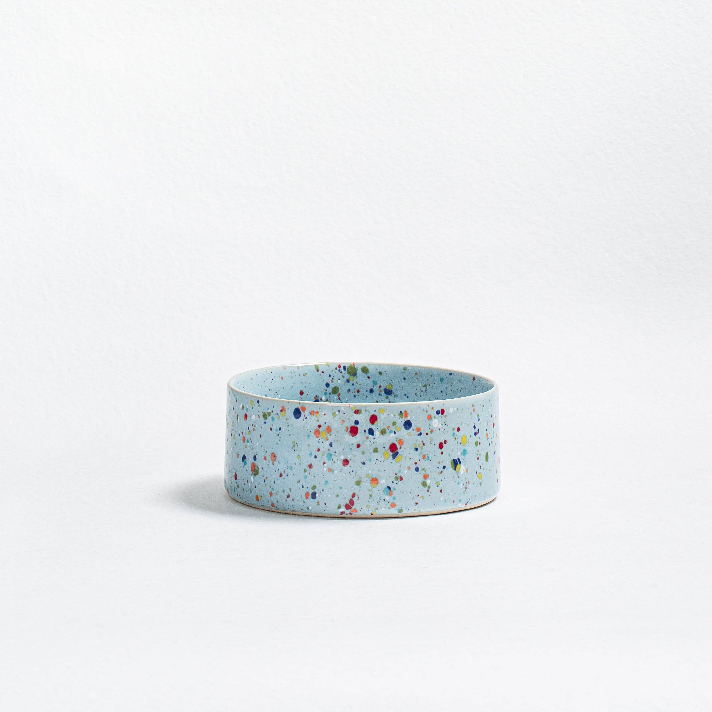 Close-up of a single New Party pet bowl showing the unique handcrafted blue speckled ceramic texture.