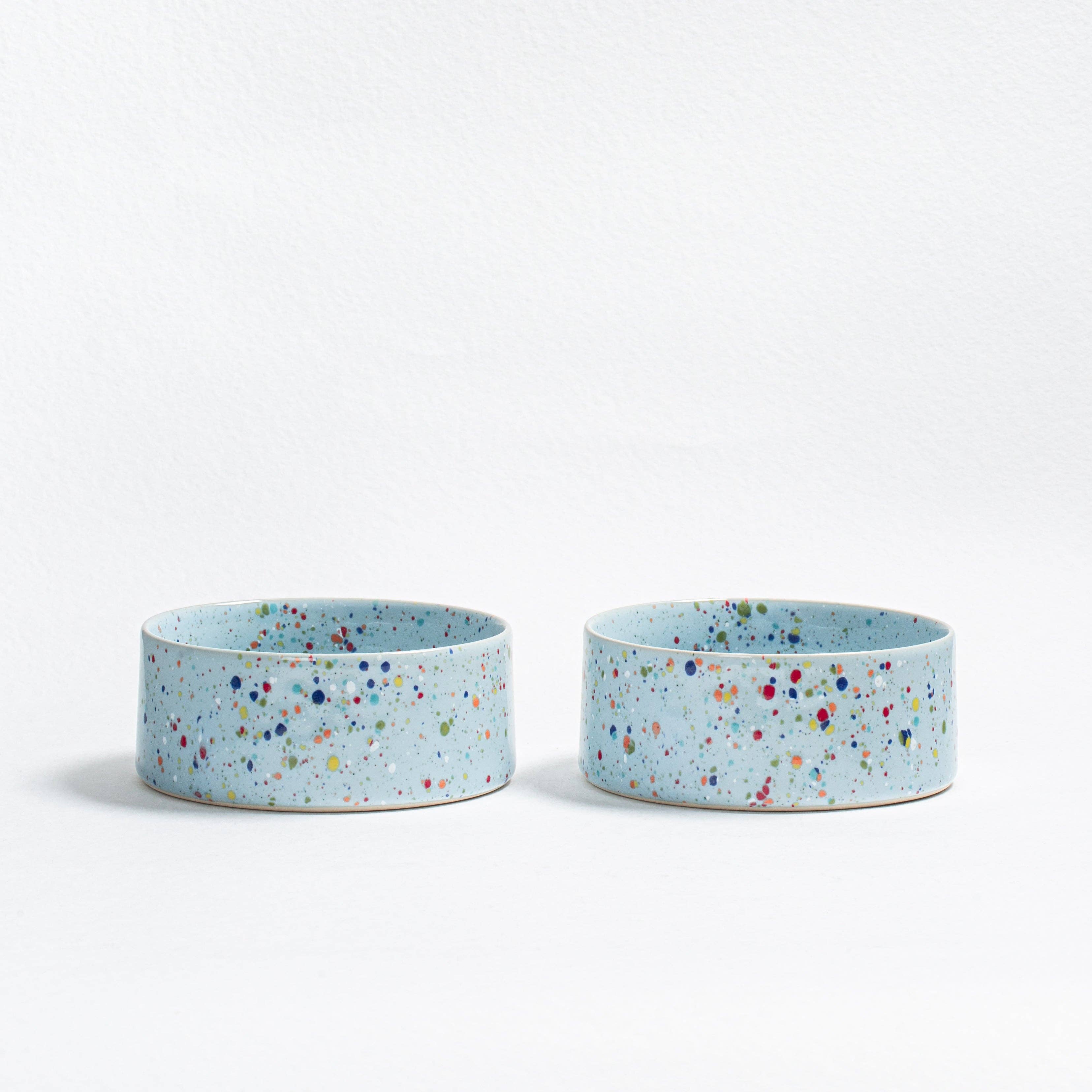 A matching set of two Soft Blue New Party pet bowls in handcrafted speckled stoneware.