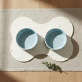 Soft Blue Splatter 16.5 cm bowls on a bone-shaped placemat