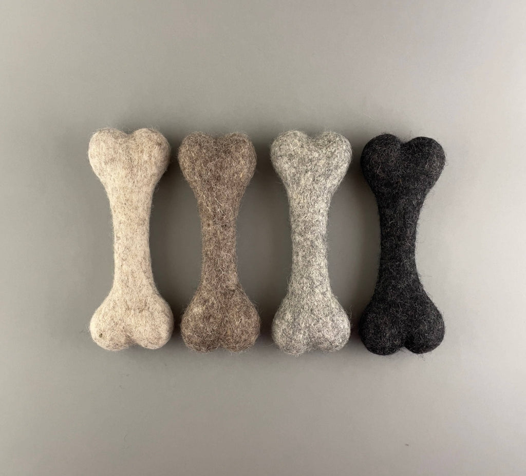 Row of four 20 cm felted wool dog bones in natural wool shades