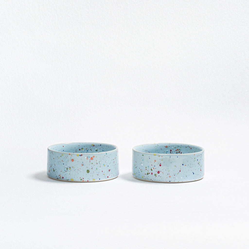 Two Soft Blue Splatter stoneware cat and small dog bowls on a white background